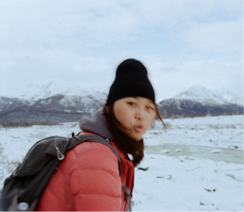 Motion shot of a lady in hiker gear in the middle of an ice field.