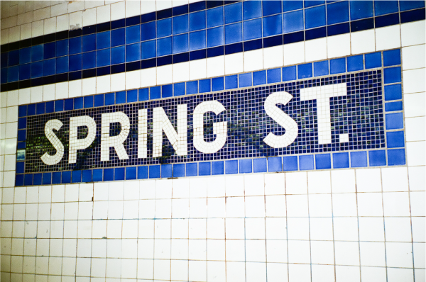 Blue, and white tiles spell out Spring Street, for the metro station.